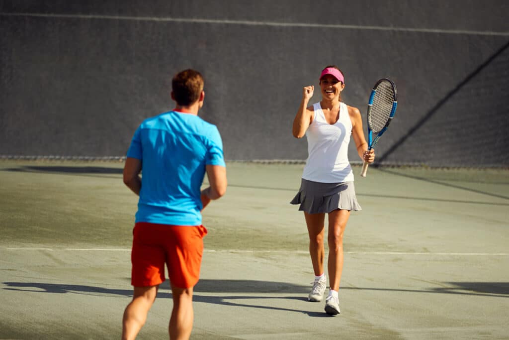 2 personnes terminant une partie de tennis