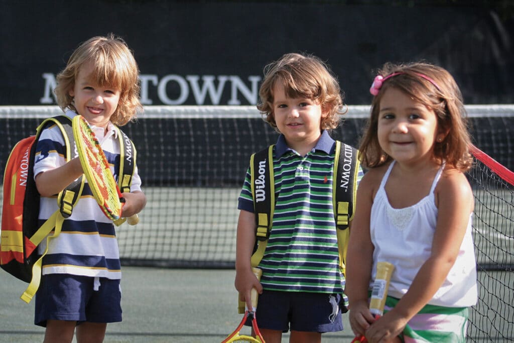 3 kids participating in Midtown Athletic Club's junior tennis program
