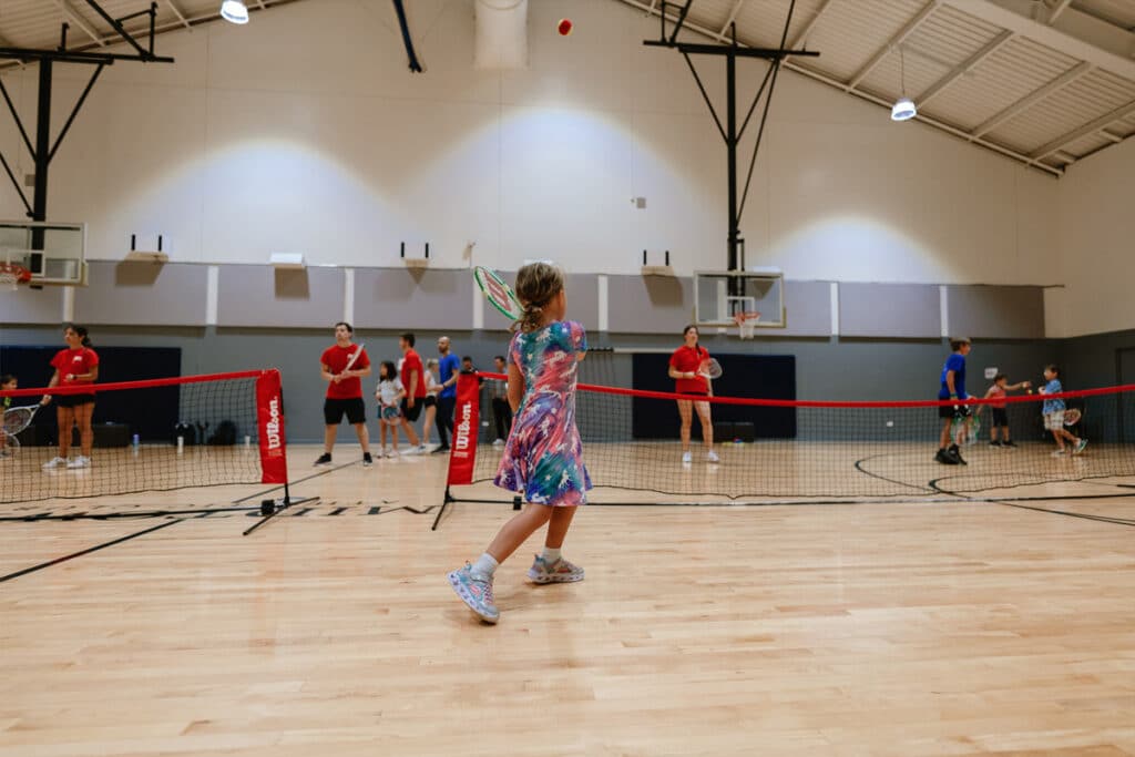 People playing tennis in a gymnasium
