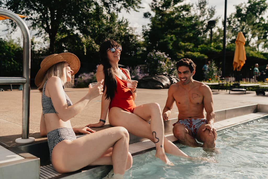 Three members sitting near outdoor pool at Midtown Athletic Club Palatine