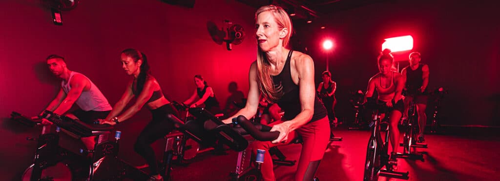 Members ride spinning bikes in RIDE studio.
