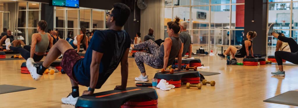 Members perform group exercise in studio.