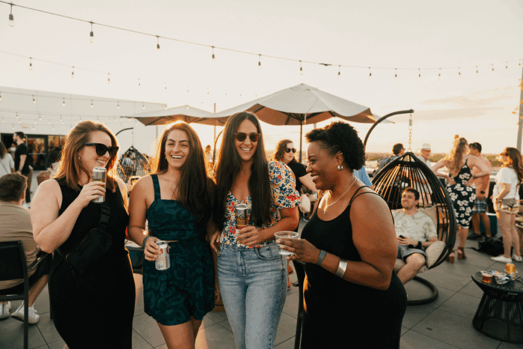 Lively rooftop gathering at Midtown Chicago with guests enjoying cocktails, shaded seating, and a vibrant community atmosphere.