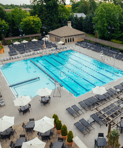roc amenities poolarc Tables, lounge chairs and surround an empty pool.